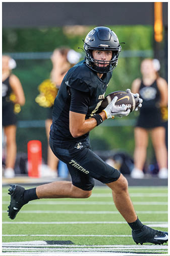 A football player running on the field. Description generated by AI