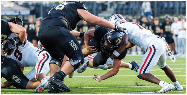 A group of football players on a field. Description generated by AI