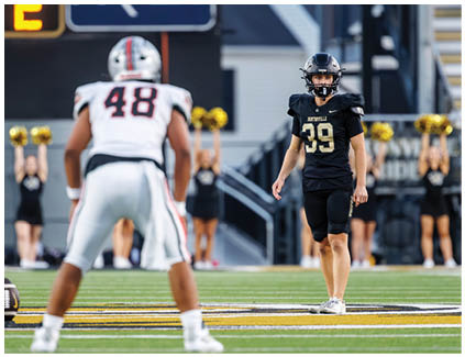 Two football players on a field. Description generated by AI