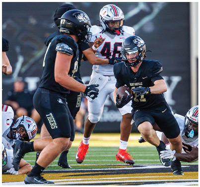 A football player is running with the ball. Description generated by AI