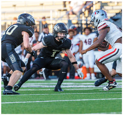 A football player in a black jersey with the number 7 on it. Description generated by AI