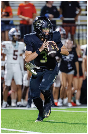 A football player in a black jersey with the number 3 on it. Description generated by AI