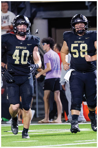 Two football players walking on the field. Description generated by AI