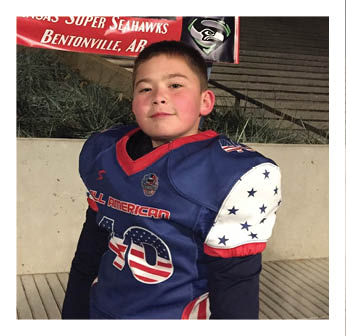 A young boy wearing a football jersey. Description generated by AI