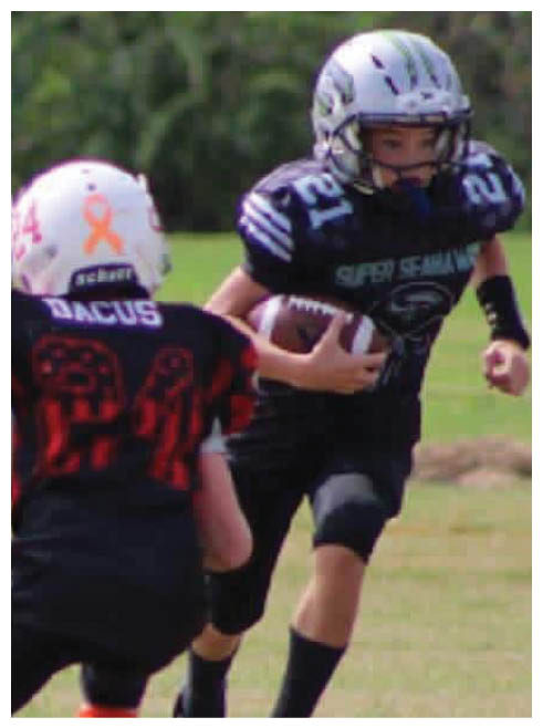 Two boys playing football. Description generated by AI