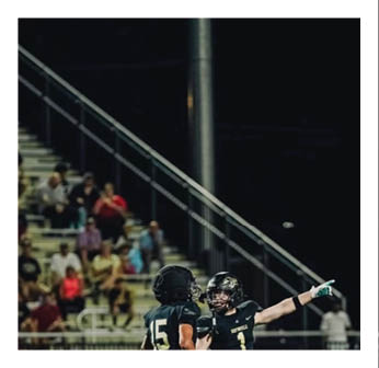 A football player wearing a black jersey with the number 15 on it. Description generated by AI