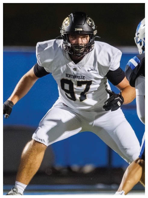 A football player wearing a black and white uniform with the number 47 on the back. Description generated by AI
