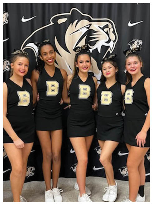 Five girls wearing black and gold uniforms. Description generated by AI