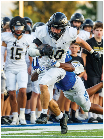 A football player is tackled by another player. Description generated by AI