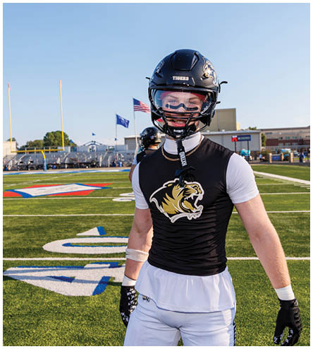 A football player wearing a black helmet and white jersey. Description generated by AI