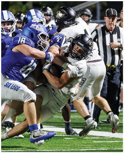 A football player is tackled to the ground. Description generated by AI
