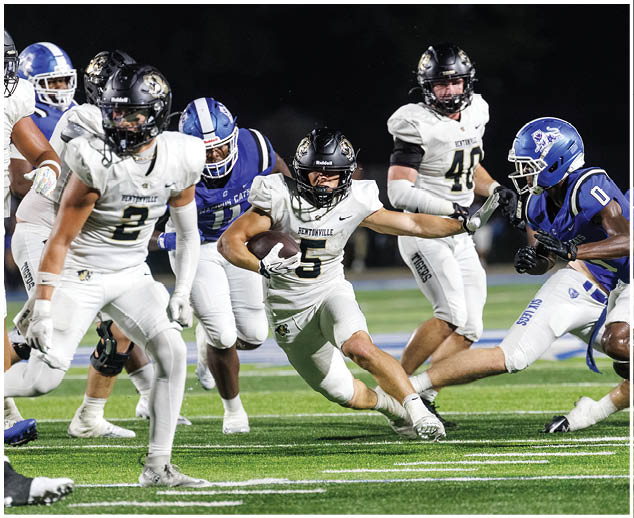 A football game in progress with players wearing white and blue uniforms. Description generated by AI