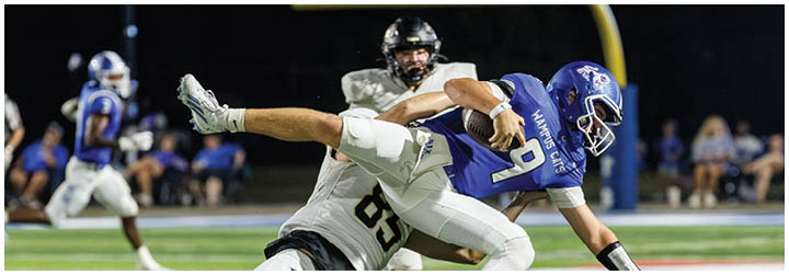 A football player is tackled to the ground. Description generated by AI