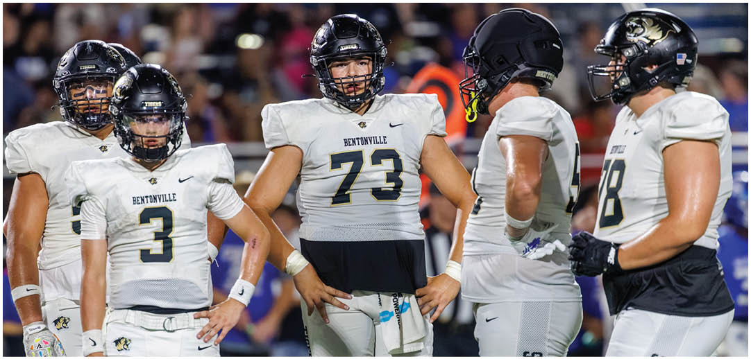 A group of football players wearing white uniforms. Description generated by AI