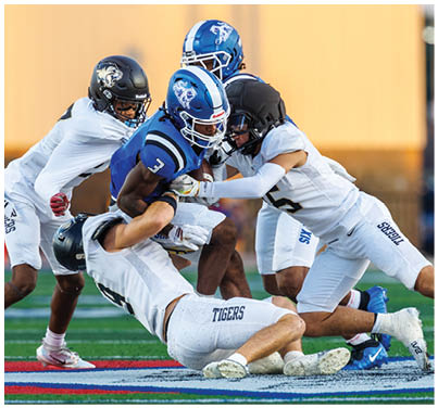 A football player is tackled to the ground. Description generated by AI