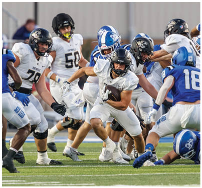 A football player is tackled to the ground. Description generated by AI