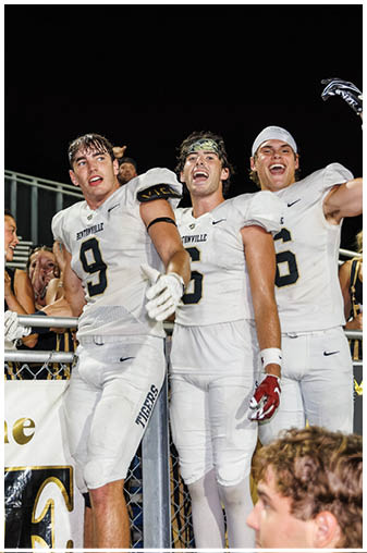 A group of football players celebrating a touchdown. Description generated by AI