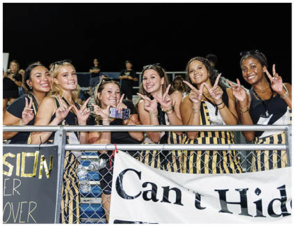 A group of cheerleaders in black and yellow uniforms. Description generated by AI