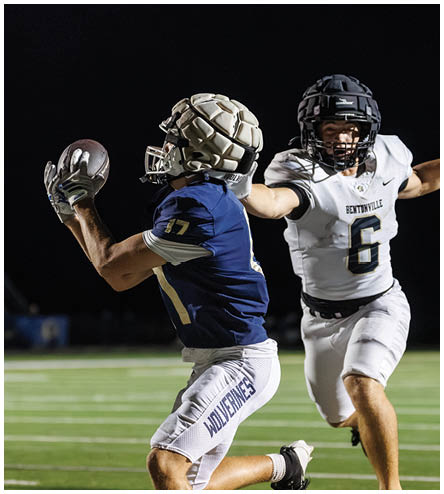 A football player wearing a black helmet and white jersey. Description generated by AI