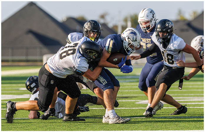 A group of football players standing on a field. Description generated by AI