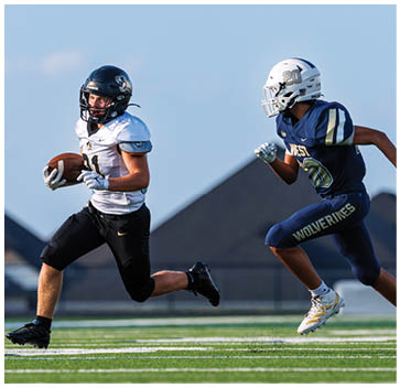 A group of football players standing on a field. Description generated by AI