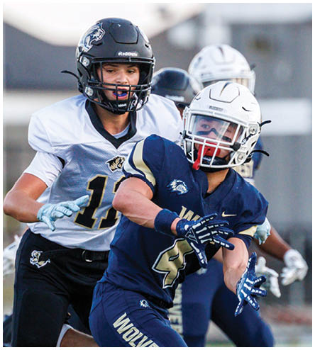 A football player wearing a black helmet and white jersey. Description generated by AI