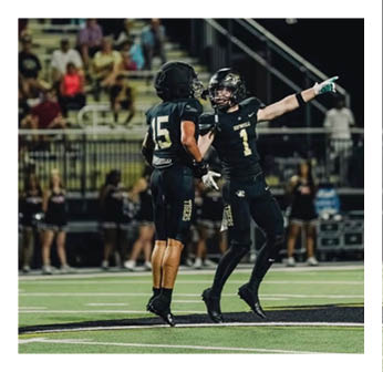 A football player wearing a black jersey with the number 15 on it. Description generated by AI