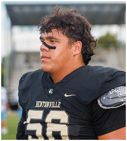 A football player wearing a black helmet and white jersey. Description generated by AI