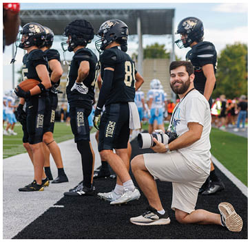 A group of football players standing on a field. Description generated by AI