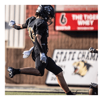 A football player in a black jersey with the number 8 on it. Description generated by AI