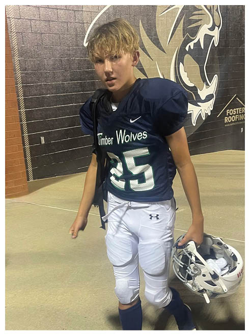 A boy wearing a football uniform with the number 25 on it. Description generated by AI