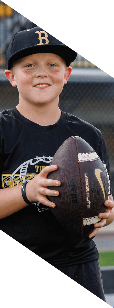 A young man wearing a football uniform is smiling and laughing. AI generated content