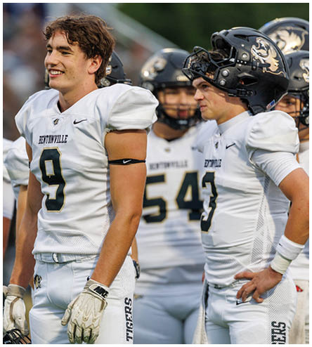A football player wearing a black helmet and white jersey. Description generated by AI