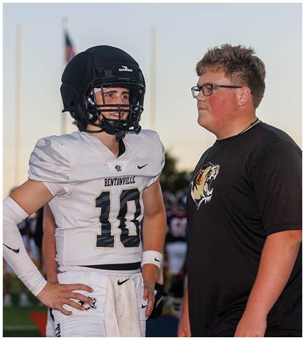 A football player wearing a black helmet and white jersey. Description generated by AI