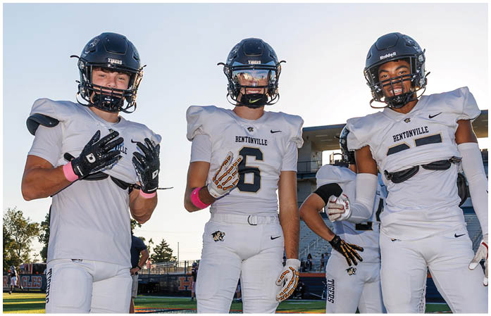 A group of football players standing on a field. Description generated by AI