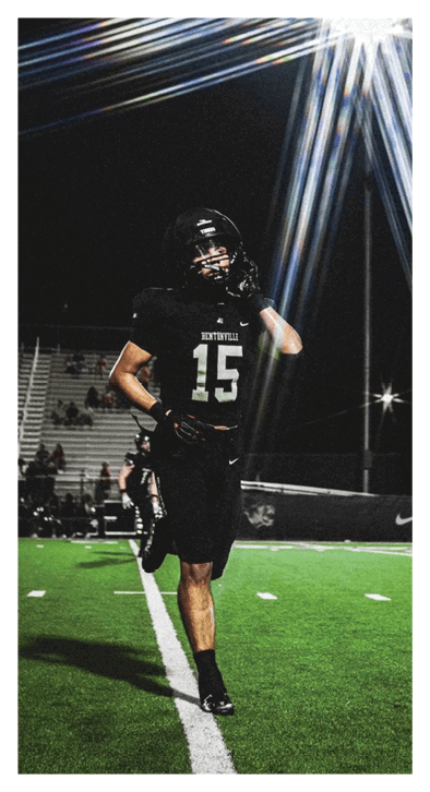 A football player running on a field at night. Description generated by AI