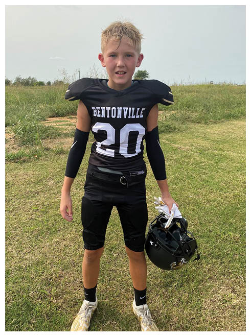 A boy wearing a football jersey with the number 20. Description generated by AI