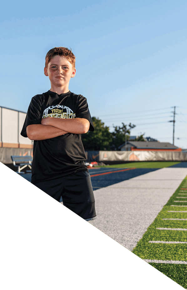 A football player is kneeling on the field, holding his helmet in his hands. AI generated content