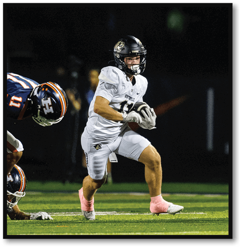 A football player wearing a black jersey with the number 6 on it. Description generated by AI
