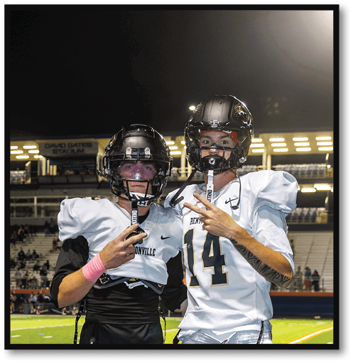 Two football players wearing black jerseys with the number 11 on them. Description generated by AI