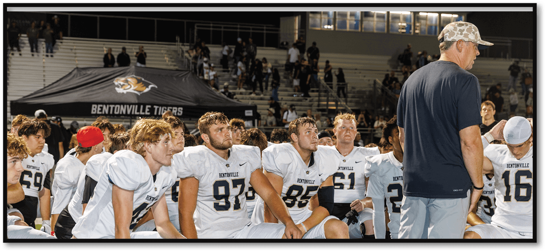 A group of football players on a field. Description generated by AI