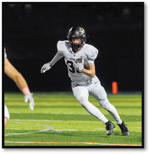 A football player wearing a black jersey with the number 6 on it. Description generated by AI
