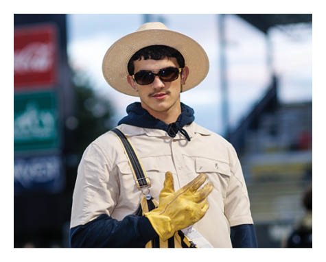 A man in a black jersey is running on a field with a football in his hand. AI generated content