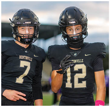 A group of football players standing on a field. Description generated by AI