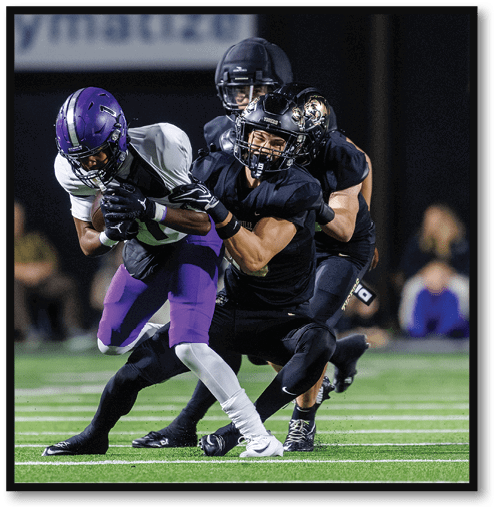 A football player wearing a black jersey with the number 6 on it. Description generated by AI