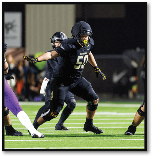 Two football players wearing black jerseys with the number 11 on them. Description generated by AI