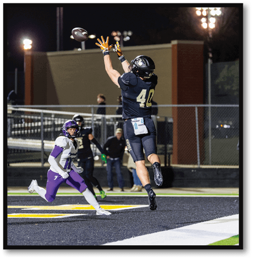 A football player wearing a black jersey with the number 6 on it. Description generated by AI