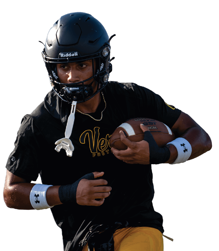 A person wearing a black helmet, black shirt, and yellow pants is running on a football field while holding a football. Descripci n generada con IA