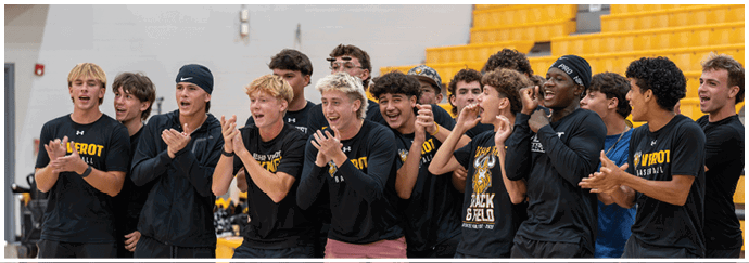 A group of people wearing matching black athletic clothing are standing closely together indoors, clapping and cheering enthusiastically. Descripci n generada con IA