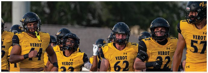Five people wearing yellow and black football uniforms with helmets are standing together outdoors. Descripci n generada con IA